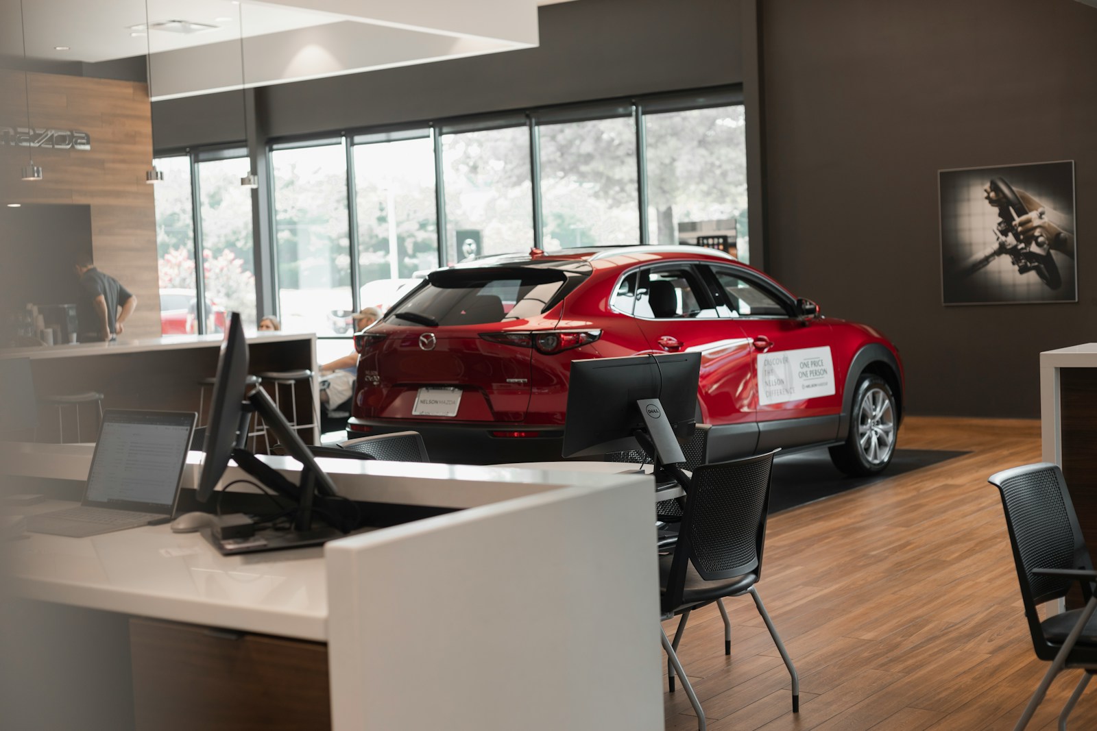 An insurance desk inside a dealership showroom, a car behind it