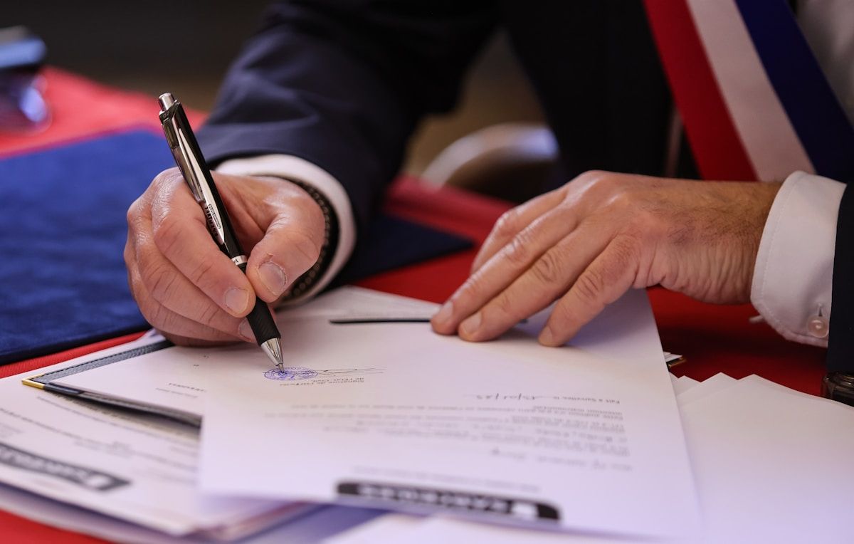 A person signing a document with a fountain pen